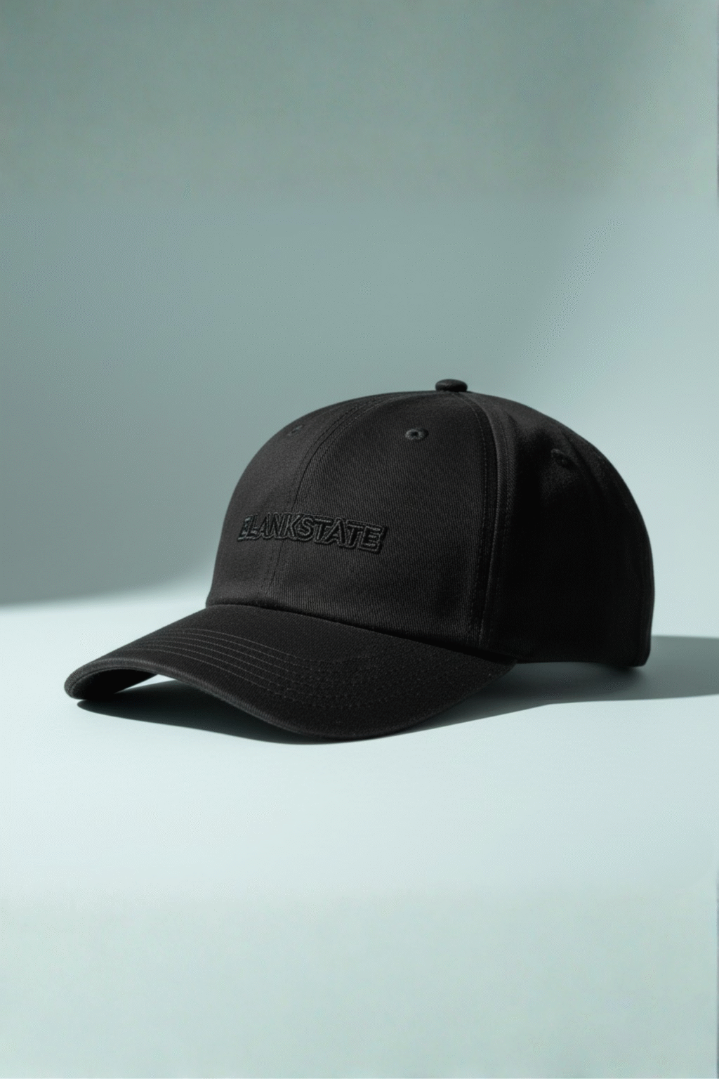 All-black cap with micro glossy outline stitch detail on pale bluish background