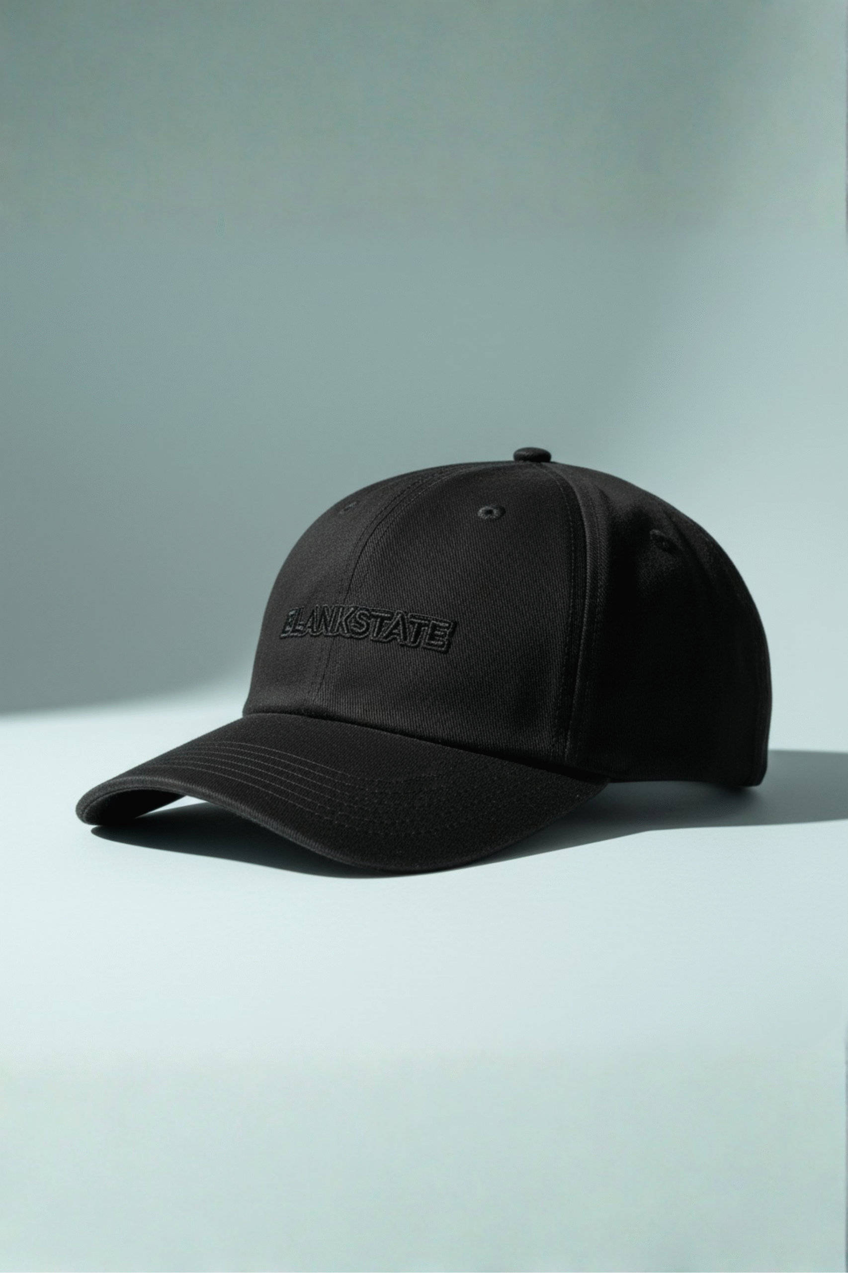 All-black cap with micro glossy outline stitch detail on pale bluish background