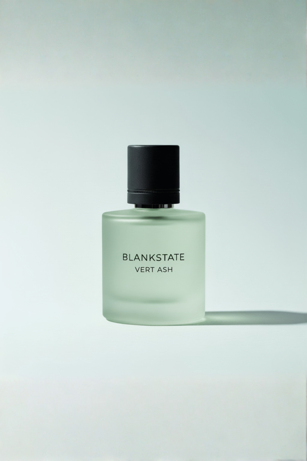 BLANKSTATE VERT ASH frosted muted-green tinted perfume bottle on pale bluish background