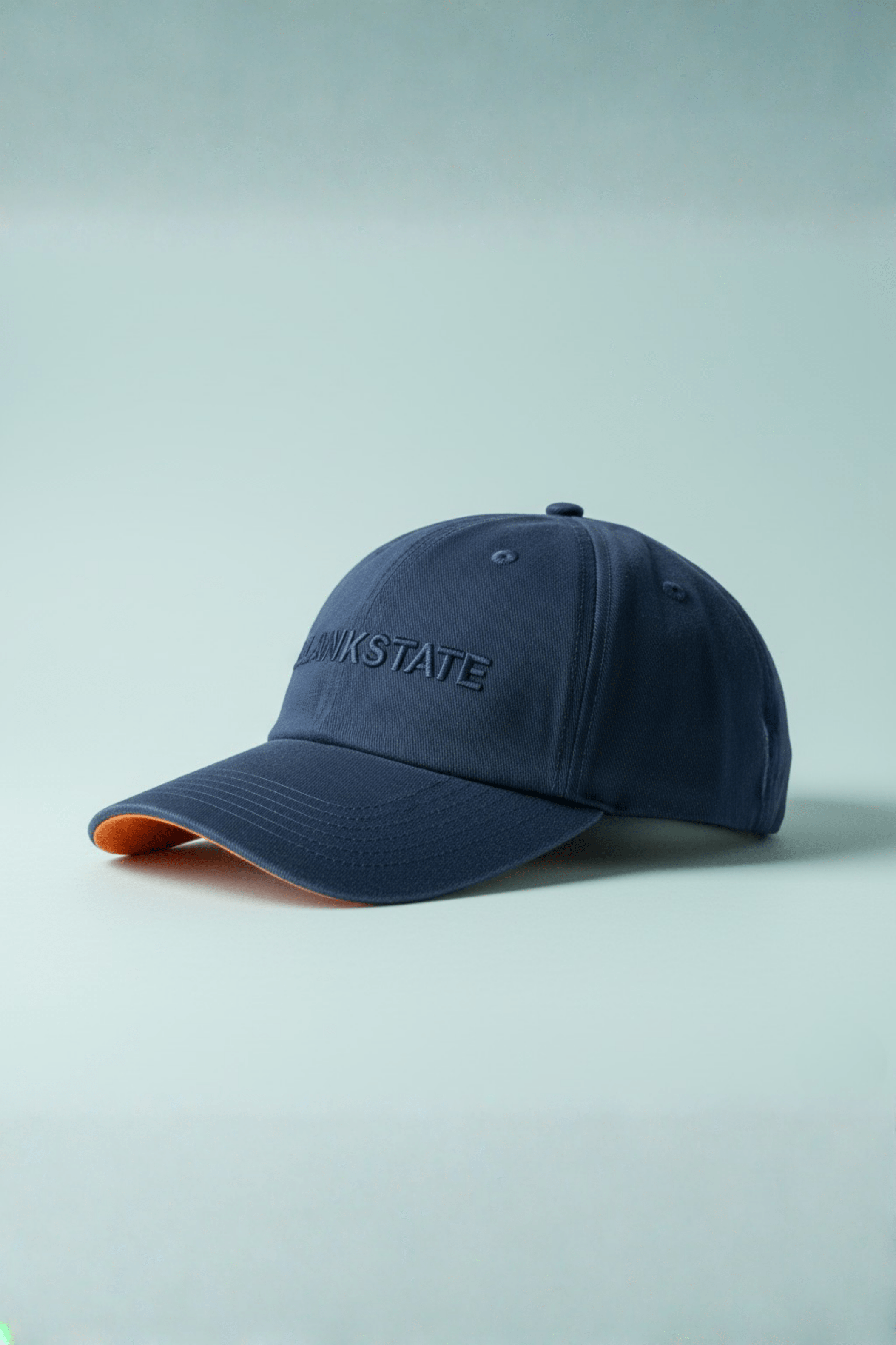 Navy cap with orange underbill and subtle embroidered wordmark on pale bluish background